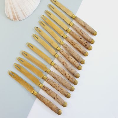 several knives are lined up on a table with a seashell in the background