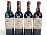 trois bouteilles de vin rouge posées l'une à côté de l'autre sur une surface blanche