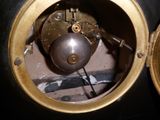gros plan d'une horloge avec une boule de métal au centre