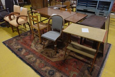 de nombreuses chaises et tables dans une pièce recouverte d'un tapis