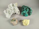 trois morceaux de minéral vert et blanc sur une surface blanche
