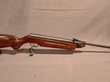 an old rifle is sitting on a white surface with a keychain
