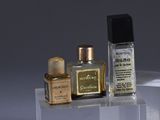 two bottles of perfume sitting on top of a clear shelf