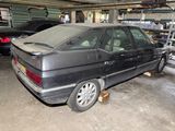 a car that is parked in a garage next to other cars