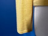 a close up of a yellow shirt hanging on a toilet