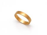gros plan d'une bague en or sur fond blanc