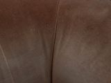a cat that is sitting on top of a brown chair