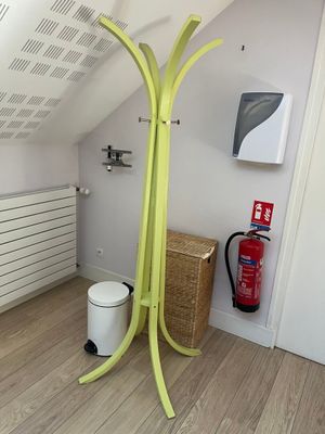 a yellow coat rack in the corner of a room