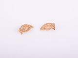 une paire de boucles d'oreilles en or sur fond blanc