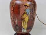 une lampe sur laquelle est représentée une femme en robe jaune