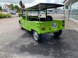 a green vehicle that is parked in a parking lot