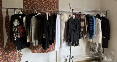 many clothes hanging on a rack in a room