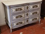 une commode blanche ornée d'un motif bleu et or