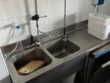 deux éviers dans la cuisine avec deux robinets sur le plan de travail