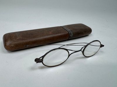 une paire de lunettes et un étui en bois posés sur une table
