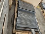 many pieces of metal on a pallet in a warehouse