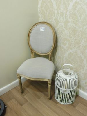 une chaise et une cage à oiseaux dans un coin de la pièce