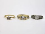 three gold and silver rings with diamonds on them