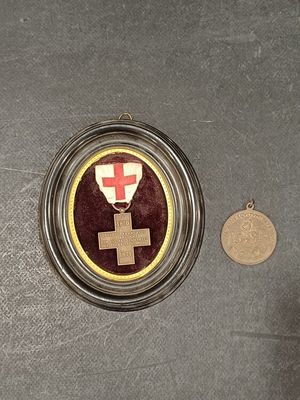 a medal with a cross on it next to a coin