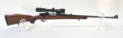 le fusil repose sur un support transparent équipé d'une lunette de visée
