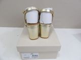 pair of white and gold high heeled shoes sitting on top of a box