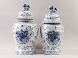 two blue and white vases with a coat of arms on them