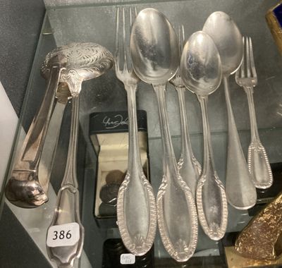 a lot of silver spoons and spoon spoons in a glass case