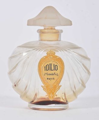 une image représentant un flacon de parfum posé sur une surface blanche