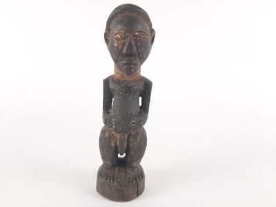 an old wooden statue of a man with a black face