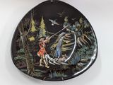 a black plate with a picture of a man fishing on it