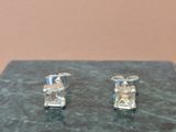 a pair of earrings that are sitting on a marble table