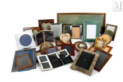 une pile de cadres photo de toutes sortes posés sur une surface blanche