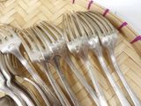 a lot of forks and spoons sitting on a plate