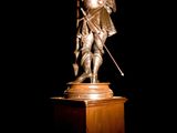 a statue of a man with a sword on a pedestal