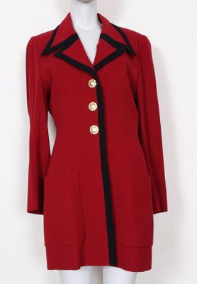 un manteau rouge avec des bordures et des boutons noirs sur un mannequin mannequin mannequin mannequin mannequin mannequin mann