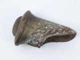 une vieille cloche en bronze posée sur une surface blanche, avec un fond blanc