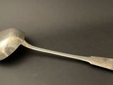 an old spoon with a metal handle sitting on a black surface