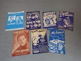 Plusieurs affiches de films anciens sont exposées sur un fond gris