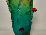 a glass vase with a cactus on it on a white surface