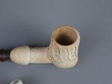 a pipe that is sitting on a table next to a flower