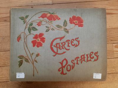 un vieux livre orné de fleurs rouges, posé sur une table en bois