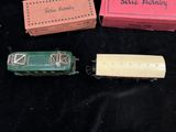 three small toy trains sitting next to each other on a black surface