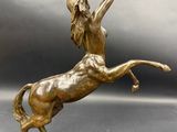 bronze statue of a woman on a horse with a crown on her head