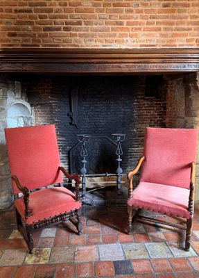 two chairs that are sitting in front of a fire place