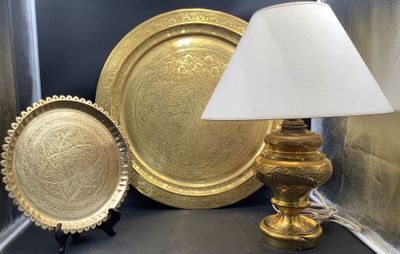 une lampe posée sur une table à côté de quelques assiettes
