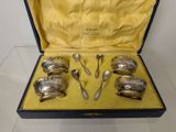 six silver spoons in a case on a table