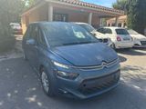 une voiture bleue garée devant un immeuble, à côté d'un parking