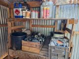 une étagère en bois sur laquelle sont posés divers outils, dans une remise