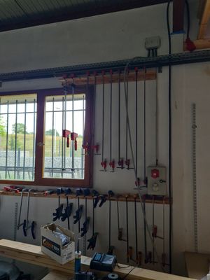 une photo d'un établi dans un garage, avec des outils suspendus au plafond