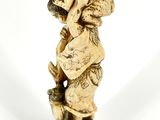 a figurine of a boy holding a bird on his head